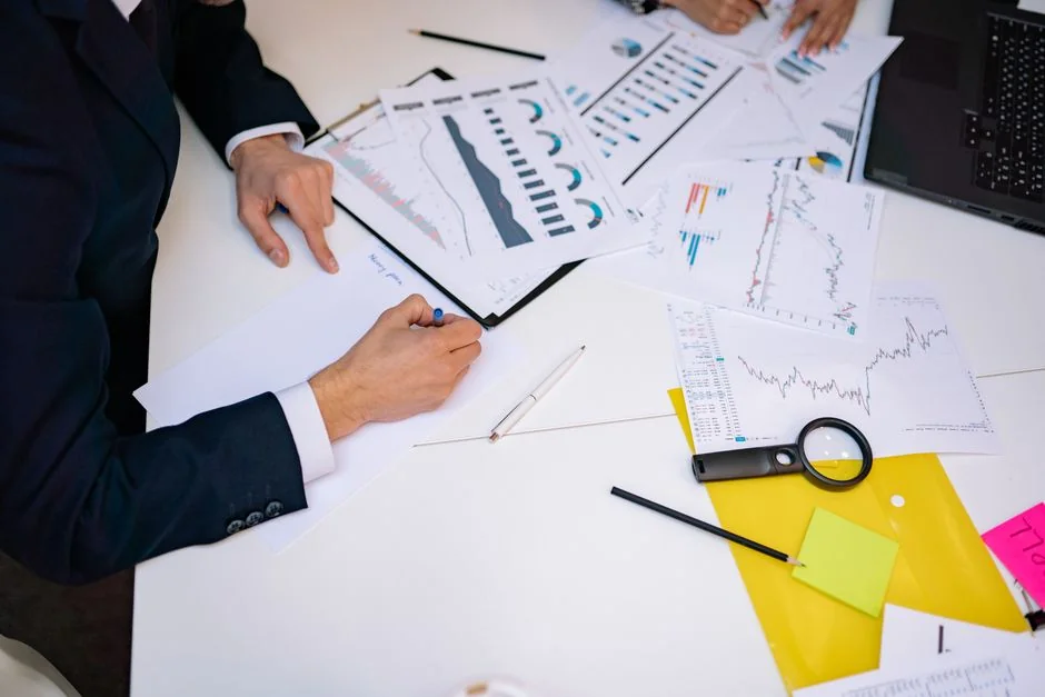 Close-up of a person writing on a business strategy document with a pen.